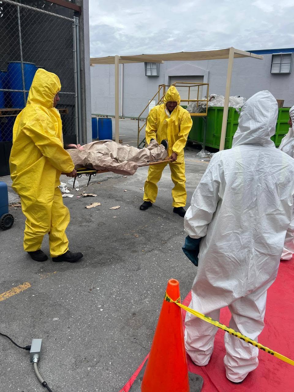 Participantes de Talenttec con trajes de protección durante una práctica de manejo de sustancias peligrosas